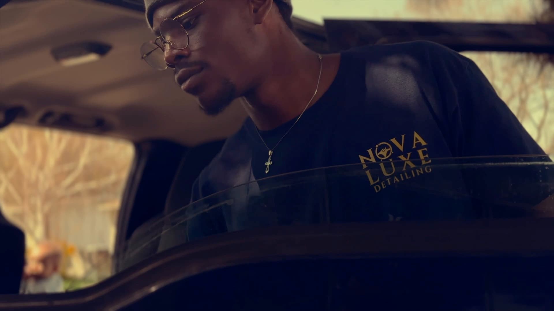 A Nova Luxe detailer working over a car's rear glass